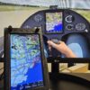 Schuwirth Flight Computer - touchscreen panel in front of flight simulator cockpit view